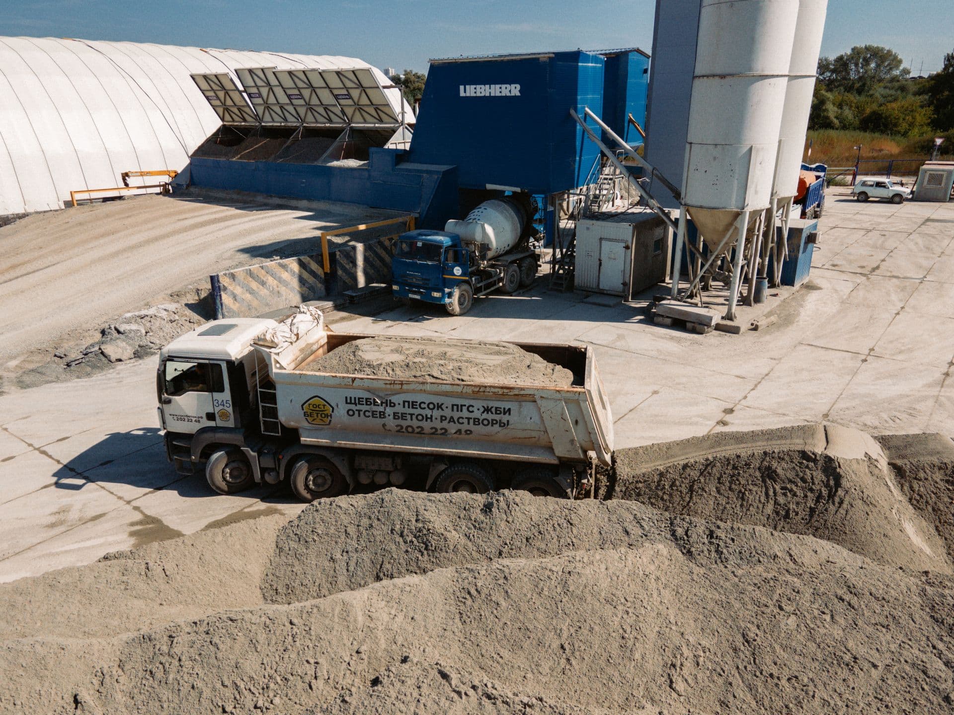 Concrete batching plant with silos, aggregate bays and a mixer truck loading