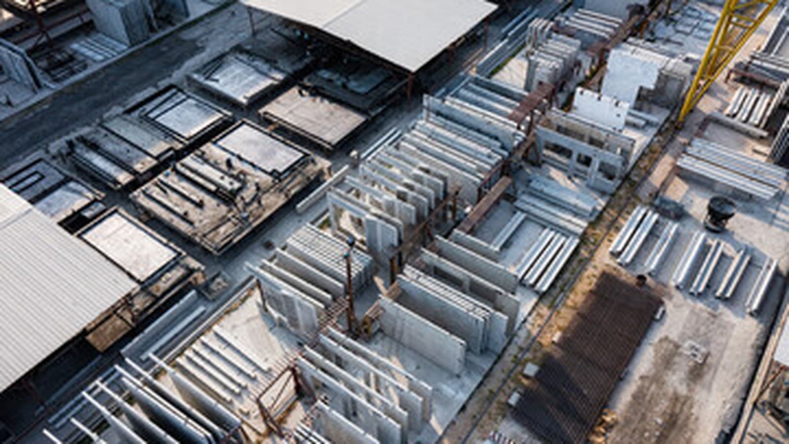 Aerial view of a precast factory yard with casting beds, moulds and stacked elements